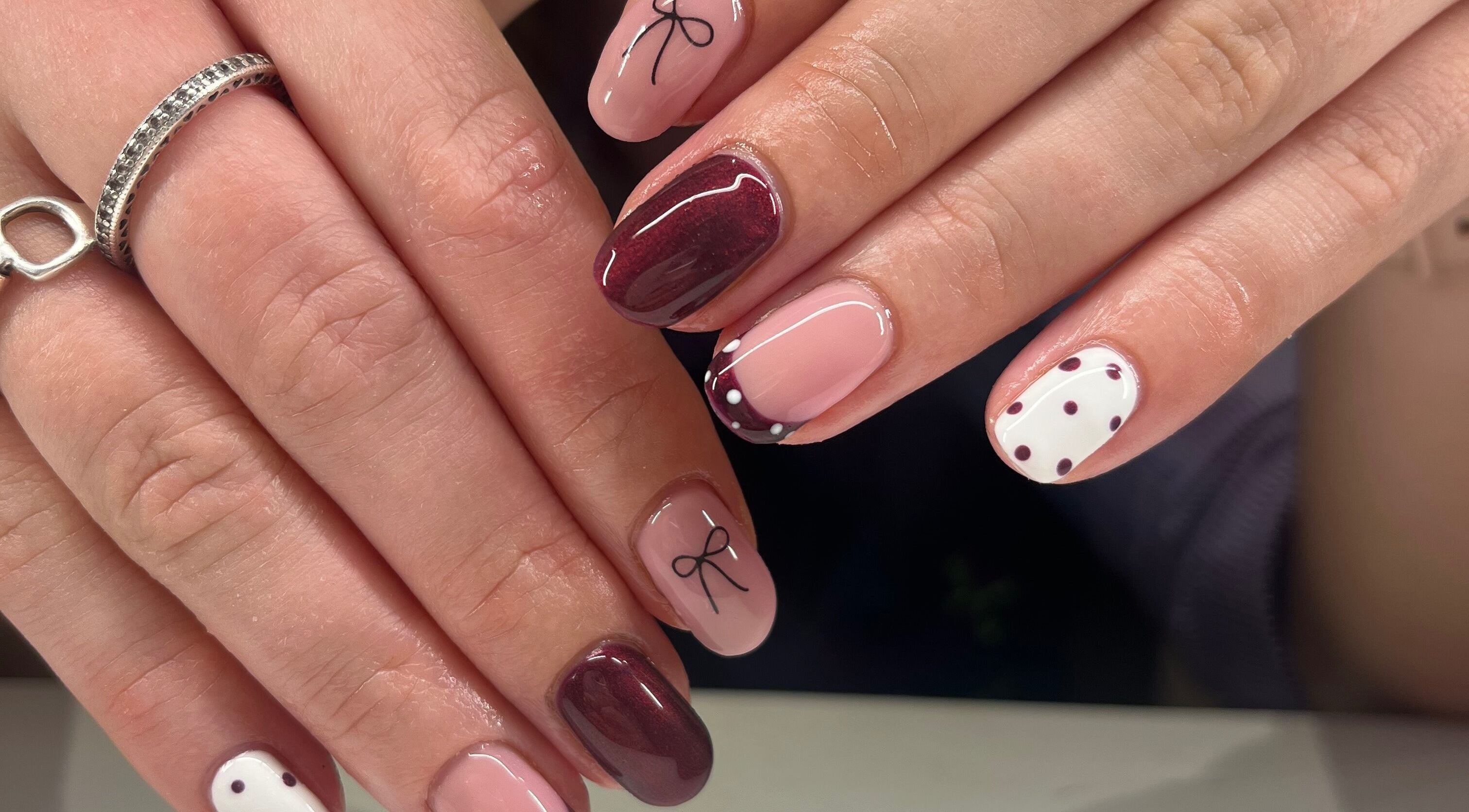 Elegant manicure featuring polka dots and ribbon design at The Beauty Shed, West, England, GB.