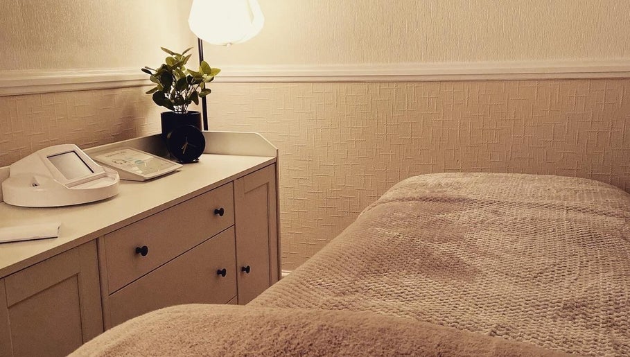 Cozy treatment room at MEMA Skin & Wellness Clinic, Lytham, GB, with soft lighting and plush bedding.