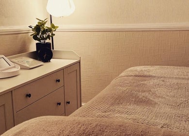 Cozy treatment room at MEMA Skin & Wellness Clinic, Lytham, GB, with soft lighting and plush bedding.