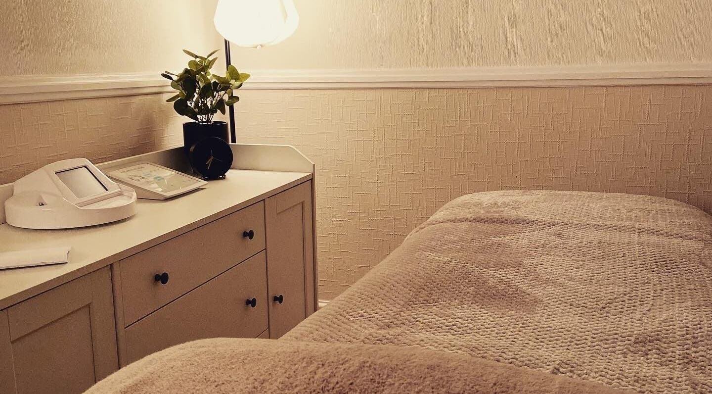 Cozy treatment room at MEMA Skin & Wellness Clinic, Lytham, GB, with soft lighting and plush bedding.