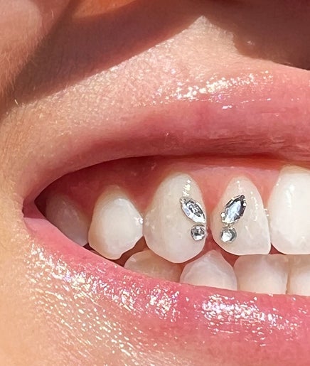 Close-up of a smile adorned with tooth gems at Twinkle Tooth Gemz, Saint Peters, New South Wales, AU.