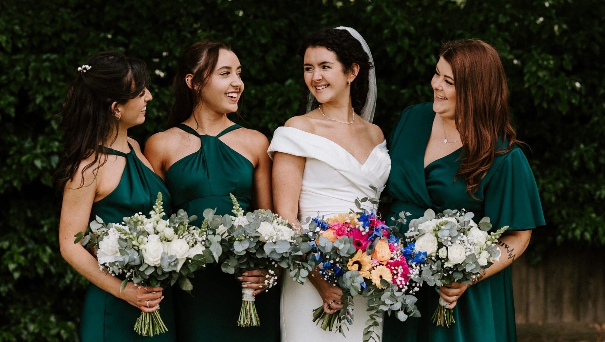 Bridesmaids with bride holding vibrant bouquets at JOAM Glow Spray Tanning, Hairdressing, Waxing, Weddings Peterborough.