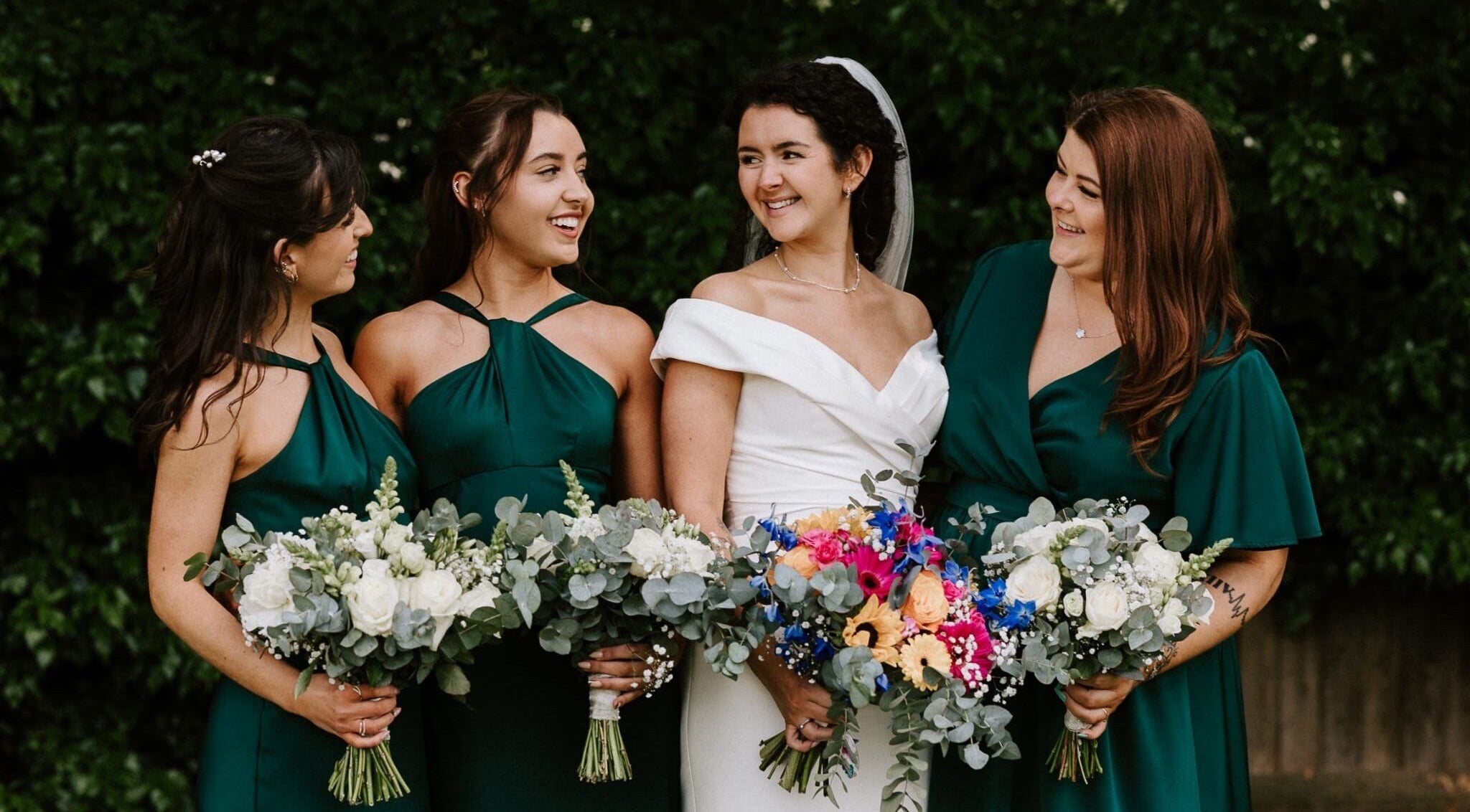 Bridesmaids with bride holding vibrant bouquets at JOAM Glow Spray Tanning, Hairdressing, Waxing, Weddings Peterborough.