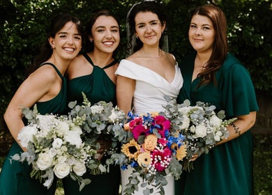 Bridesmaids in emerald dresses with floral bouquets at JOAM Glow London Mobile Spray Tanning Sienna X, London, England, GB.