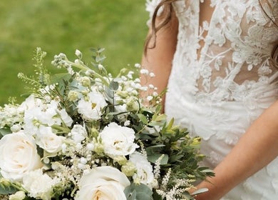 Bride holding bouquet in lace gown at JOAM Glow London Mobile Spray Tanning Sienna X, London, England, GB.