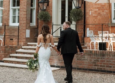 Couple in formal attire walking towards JOAM Glow London Mobile Spray Tanning Sienna X venue in London, England, GB.