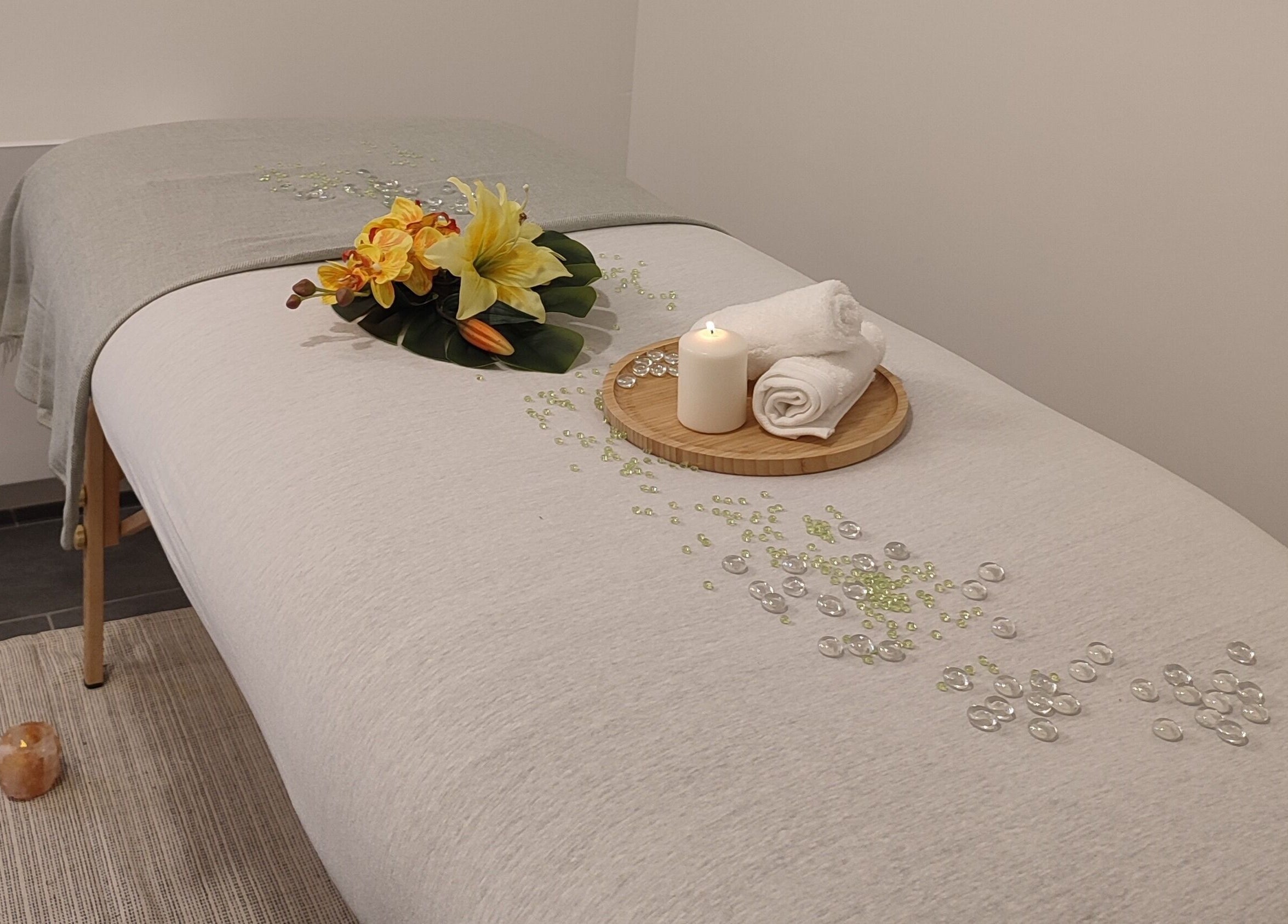 Table de massage apaisante à Énergie d'être, Auxy, Centre-val De Loire, FR, avec fleurs et bougie.