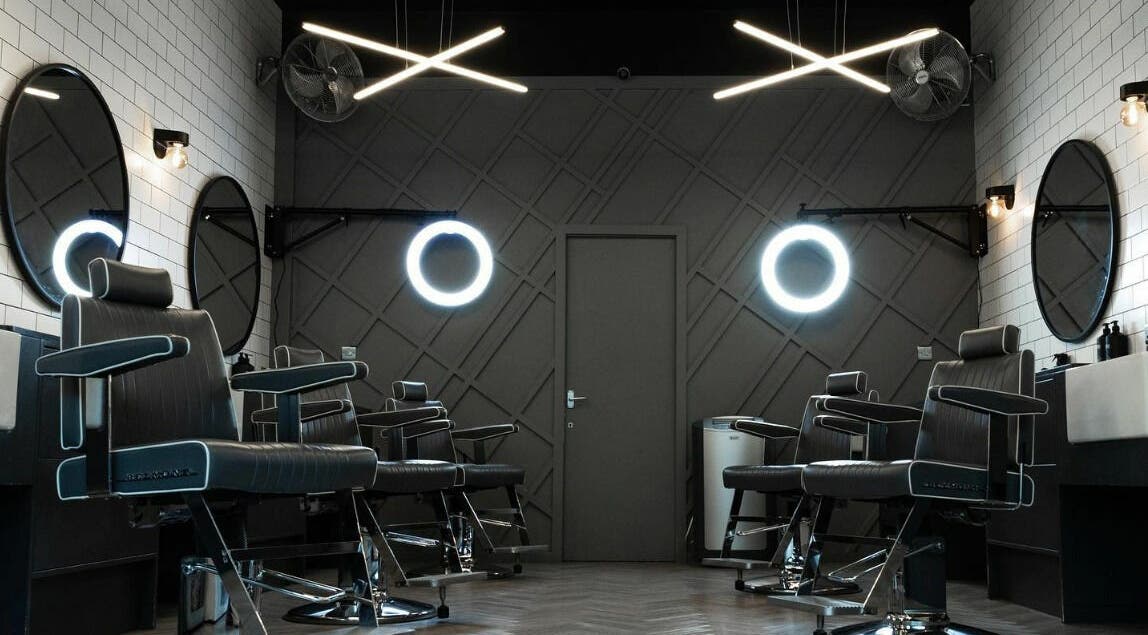 Modern barbershop interior at Kropper in London, England, GB with sleek chairs and stylish lighting.