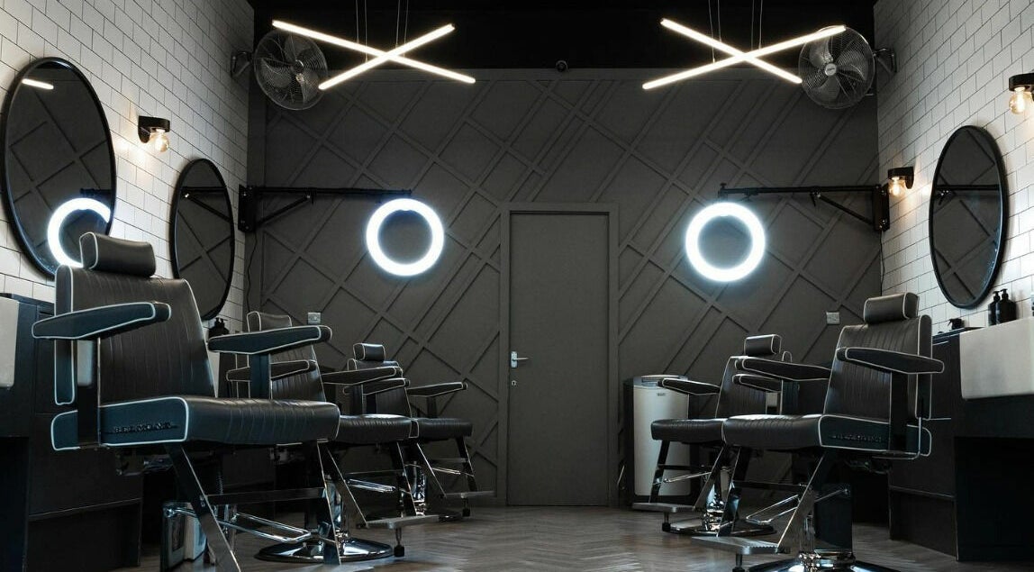 Modern barbershop interior at Kropper in London, England, GB with sleek chairs and stylish lighting.