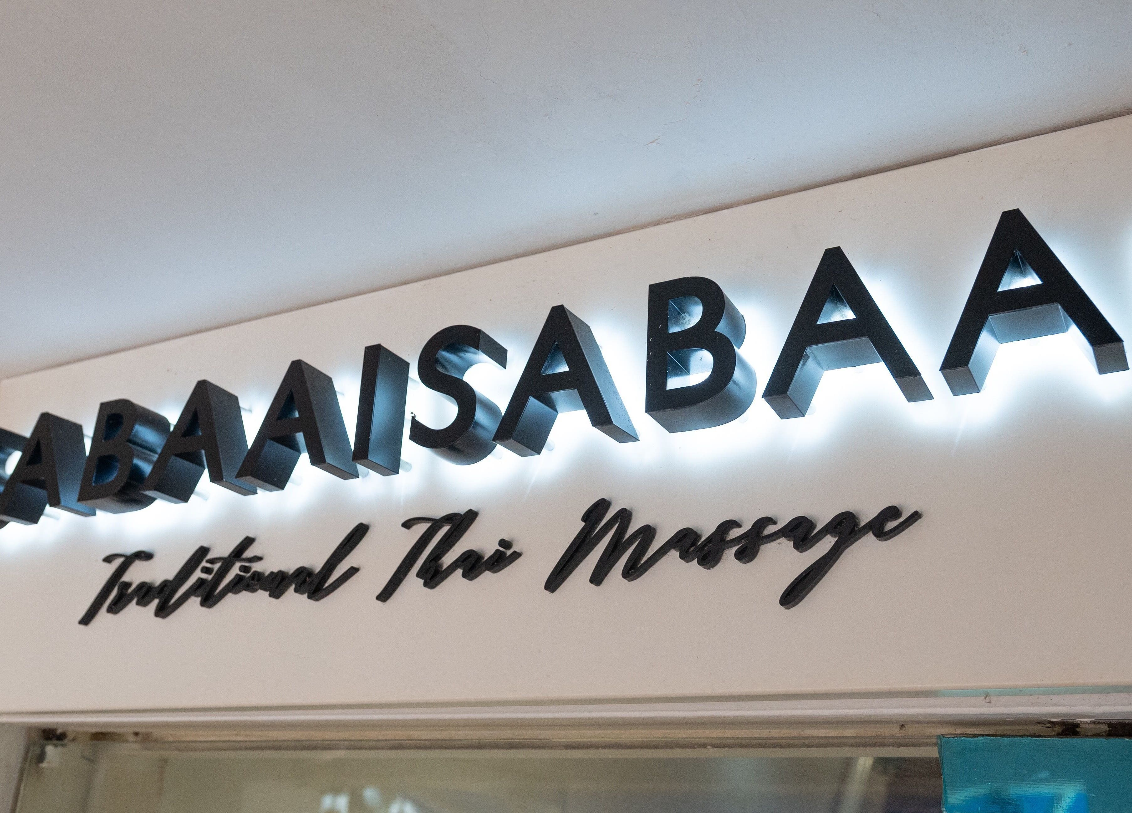 Illuminated signage of Sabaai Sabaai Traditional Thai Massage at Raffles Place, enhancing local ambiance.