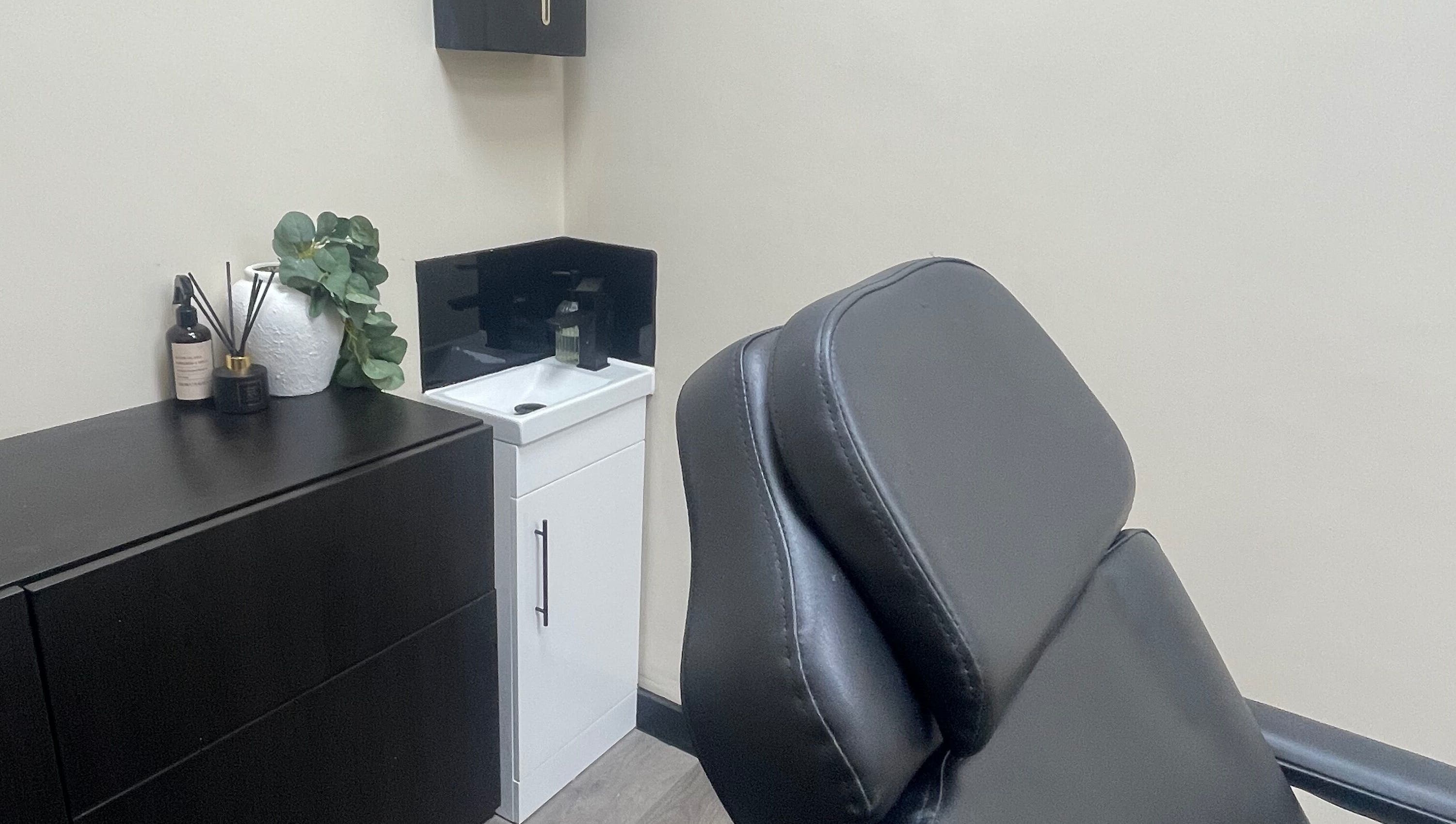 Stylish treatment room at DMW Aesthetics in Stanford-le-hope, England, GB, featuring a modern black chair.