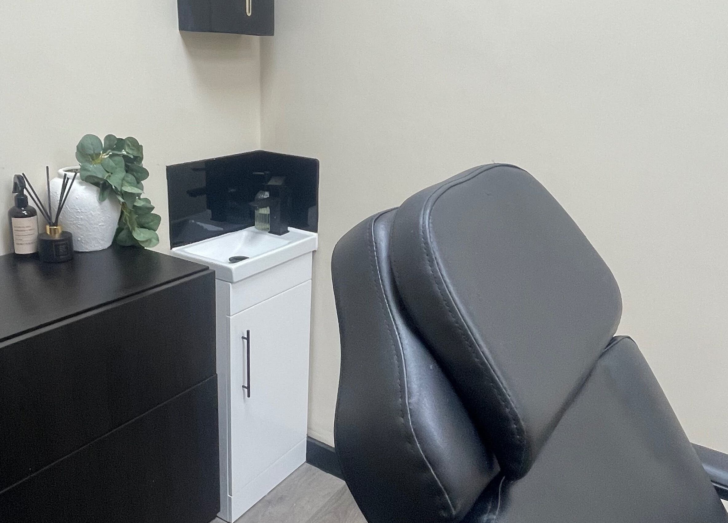 Stylish treatment room at DMW Aesthetics in Stanford-le-hope, England, GB, featuring a modern black chair.