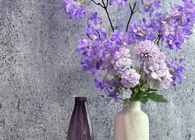 Elegante violette Blüten in Vasen dekorieren das Purple Brow Bar in Vienna, Wien, AT.