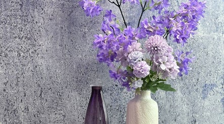 Elegante violette Blüten in Vasen dekorieren das Purple Brow Bar in Vienna, Wien, AT.