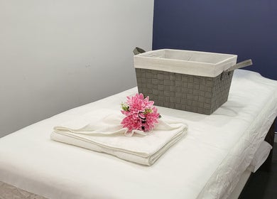 Serene massage table at Rockdale Remedial Thai Massage in Rockdale, New South Wales, AU with towels and flowers.