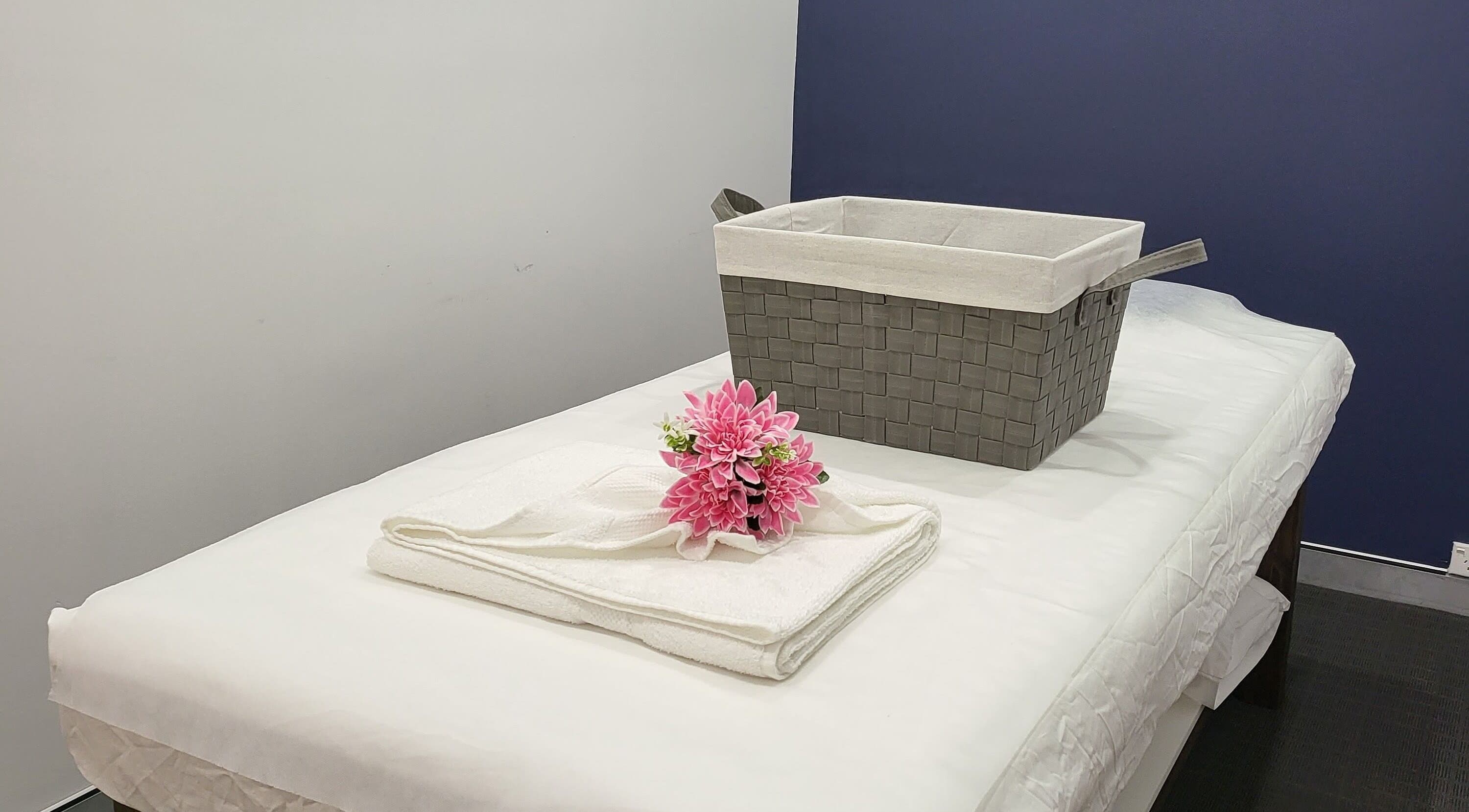Serene massage table at Rockdale Remedial Thai Massage in Rockdale, New South Wales, AU with towels and flowers.