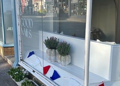 Front window of Doctor Cliona in Ripon, England, GB with elegant potted plants and nail salon decor.