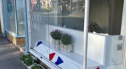 Front window of Doctor Cliona in Ripon, England, GB with elegant potted plants and nail salon decor.