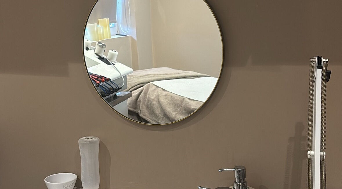 Mirror reflecting a cozy treatment room at The Beauty Hutmcr in Dukinfield, England, GB.