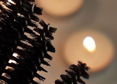 Closeup of mascara brush with candles at The Beauty Hutmcr, Dukinfield, England, GB.