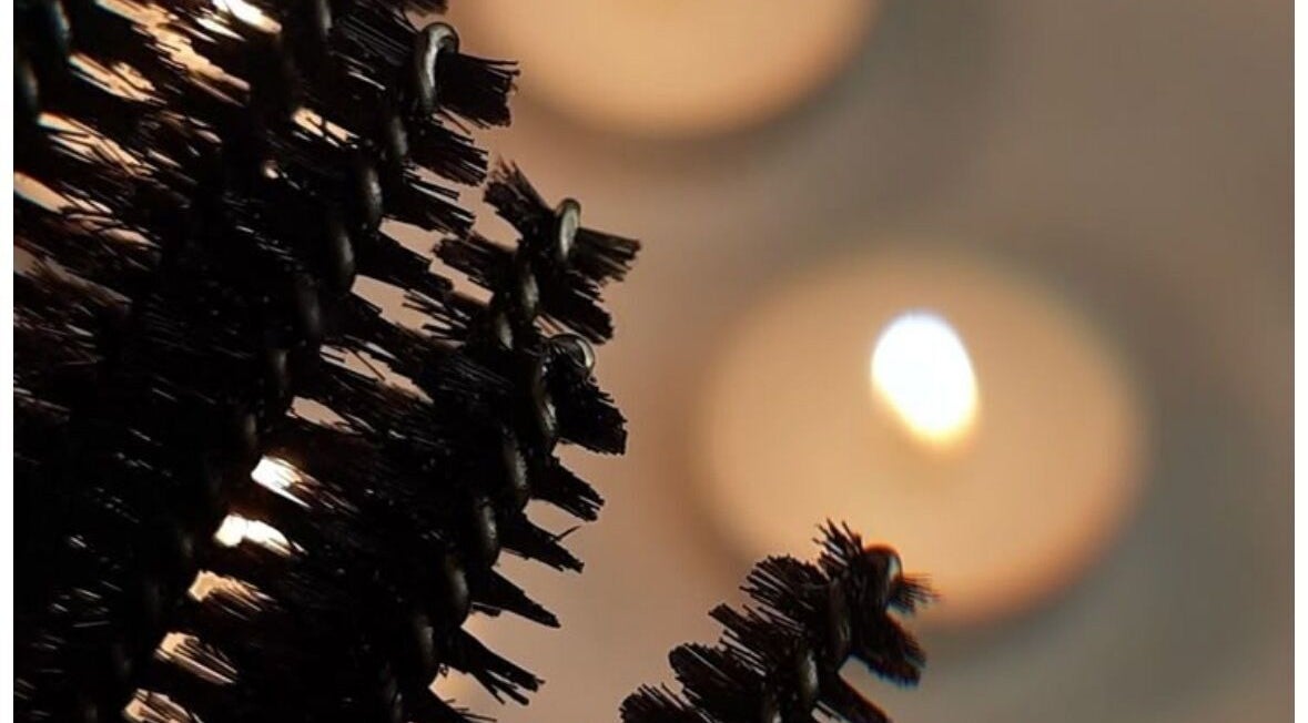 Closeup of mascara brush with candles at The Beauty Hutmcr, Dukinfield, England, GB.