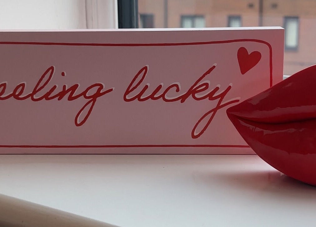 Decorative 'feeling lucky' sign with lips at Moinicures, Barry, Wales, GB.