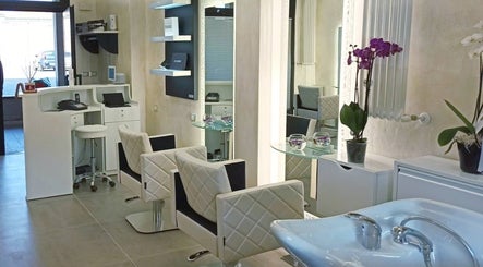 Interno elegante di Kromatik Hair Studio a Ferrara, Emilia-romagna, IT, con sedie imbottite e decorazioni moderne.