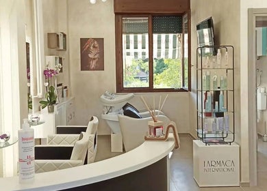 Interno moderno di Kromatik Hair Studio a Ferrara, Emilia-romagna, IT, con arredamento elegante e prodotti di bellezza.