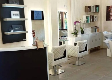 Interno di Kromatik Hair Studio a Ferrara, Emilia-romagna, IT con eleganti postazioni e prodotti per capelli.