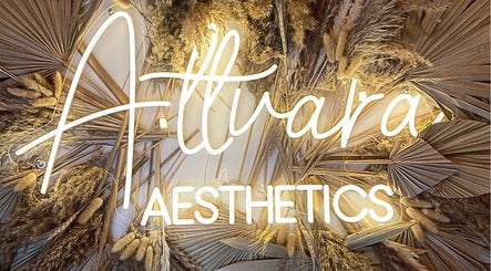 Attvara Aesthetics sign illuminated among dried palm leaves, Great Kingshill, England, GB.
