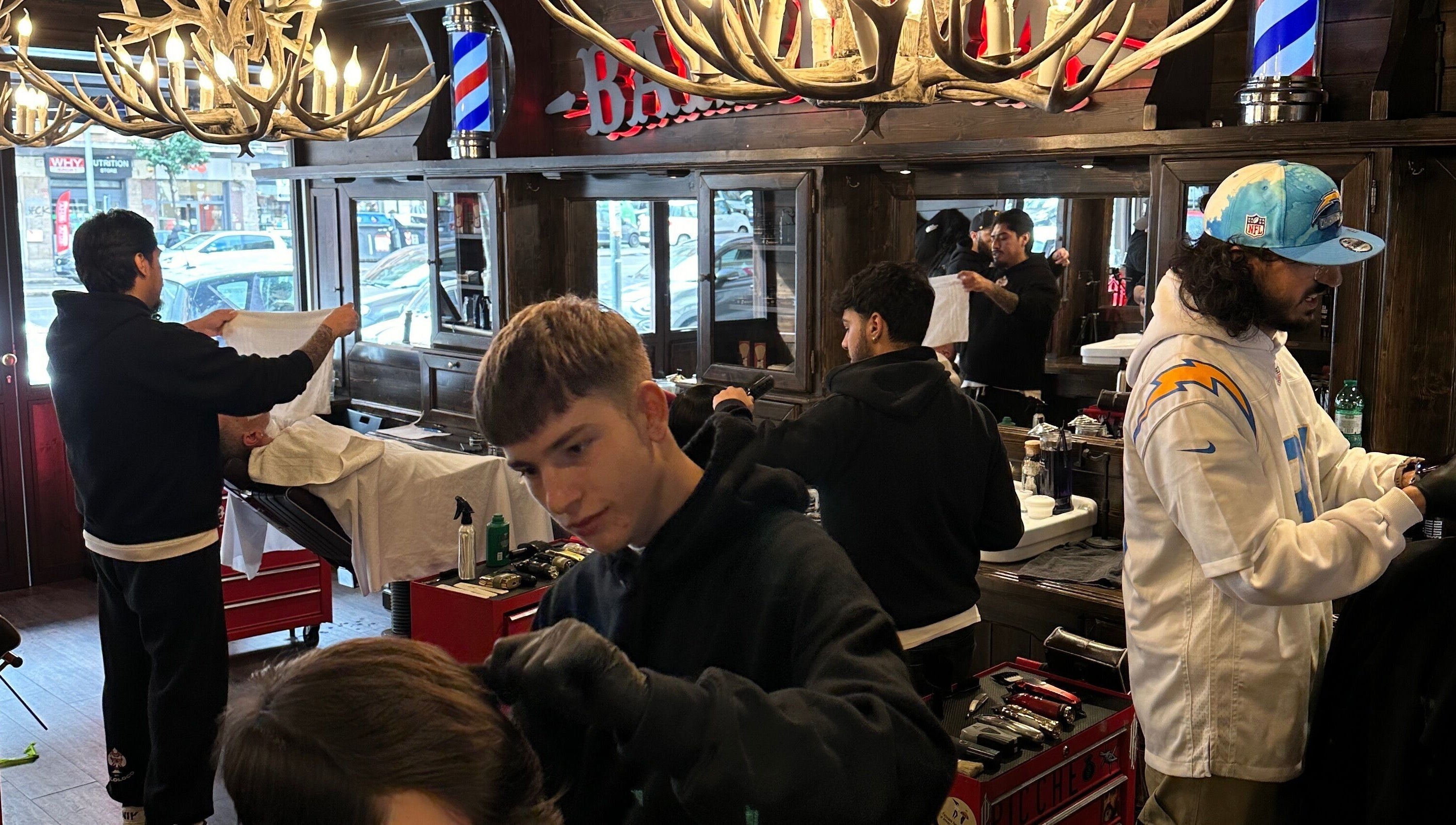 Interno del salone Peloloco Tiburtina a Roma, Lazio, IT con barbiere al lavoro.