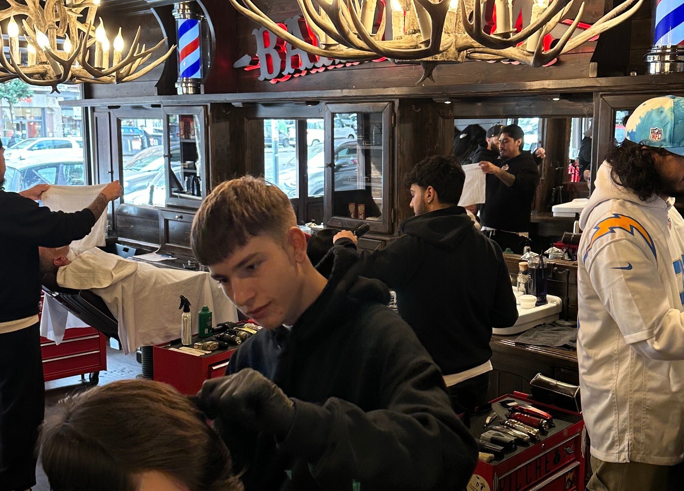 Interno del salone Peloloco Tiburtina a Roma, Lazio, IT con barbiere al lavoro.