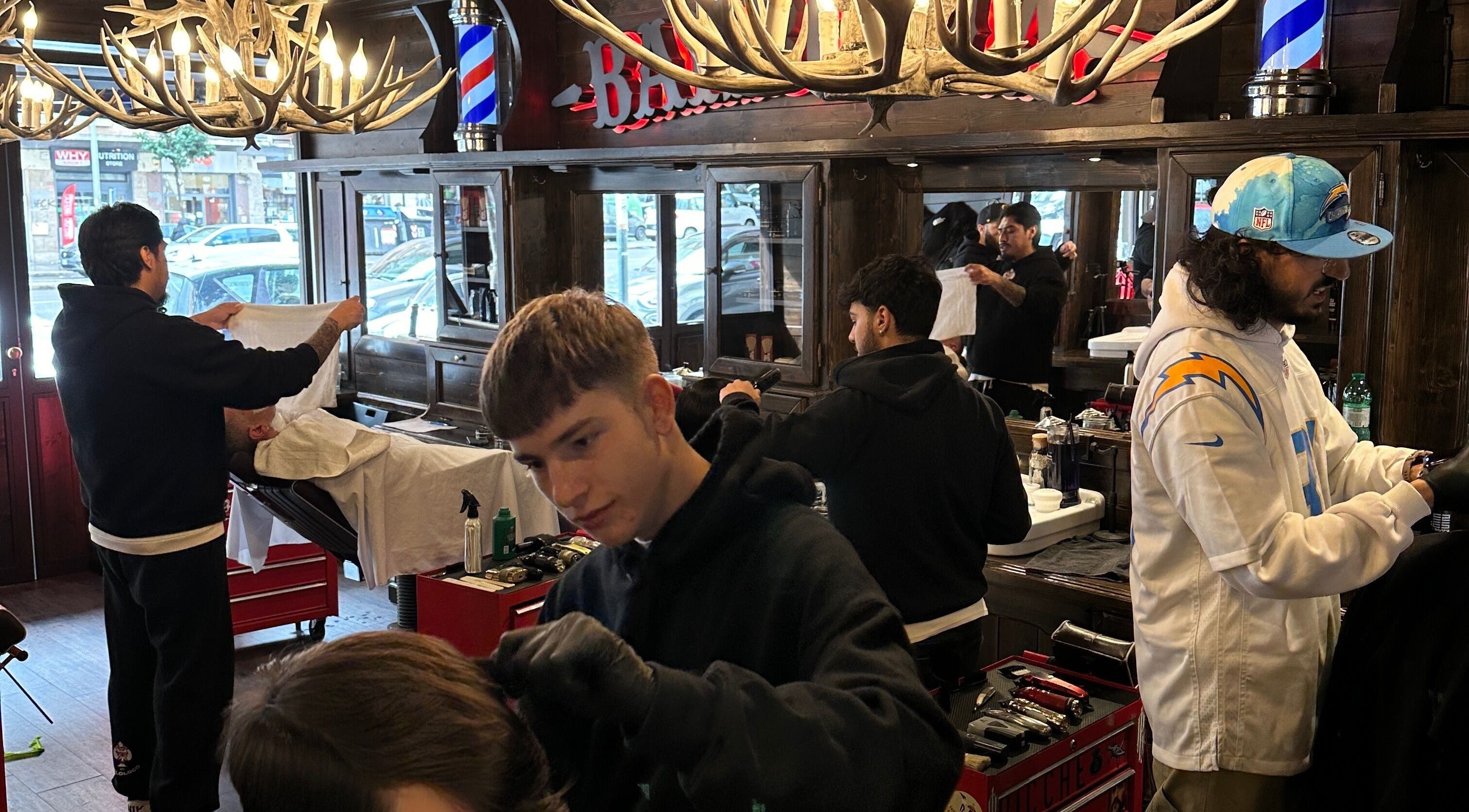 Interno del salone Peloloco Tiburtina a Roma, Lazio, IT con barbiere al lavoro.