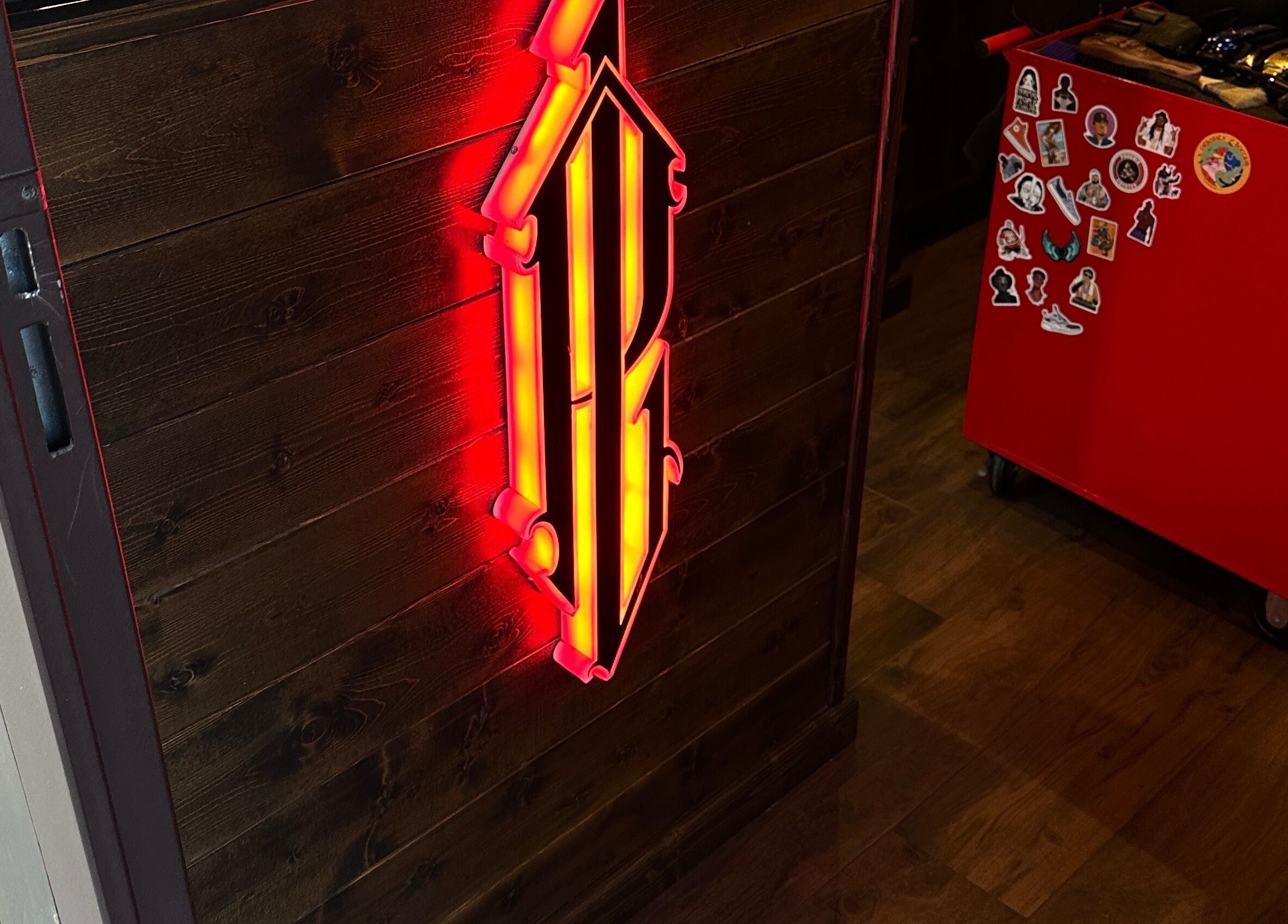 Insegna luminosa all'interno di Peloloco Tiburtina, Roma, Lazio, IT, accanto a un cartello rosso decorato.