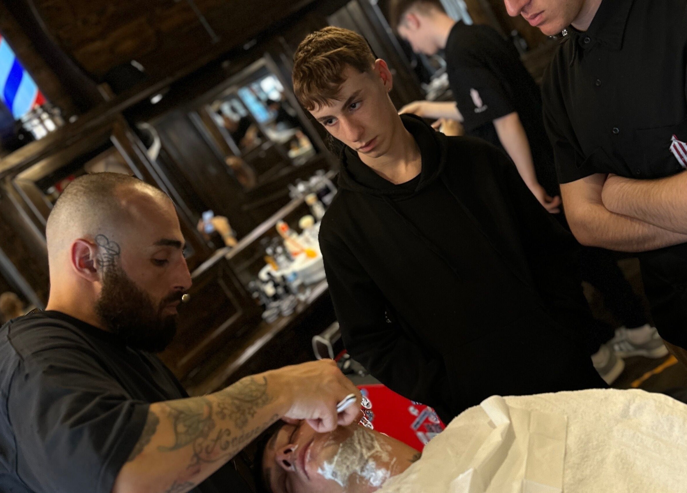 Barbiere al lavoro a Peloloco Tiburtina, Roma, Lazio, IT, mentre esegue una rasatura classica.