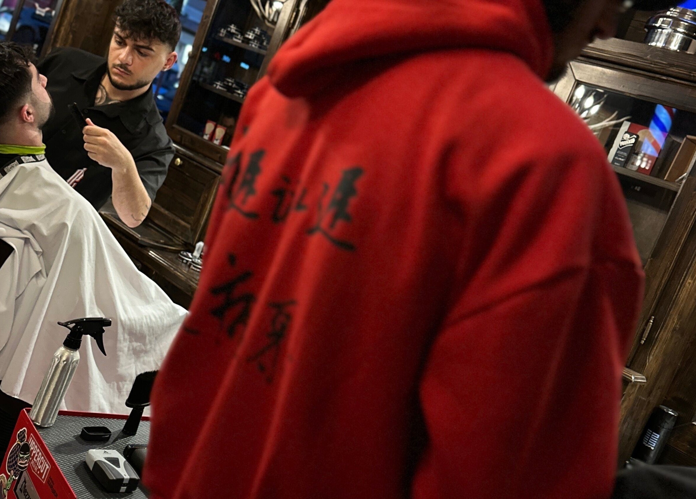 Barbiere che rifinisce barba a cliente presso Peloloco Tiburtina, Roma, Lazio, IT.