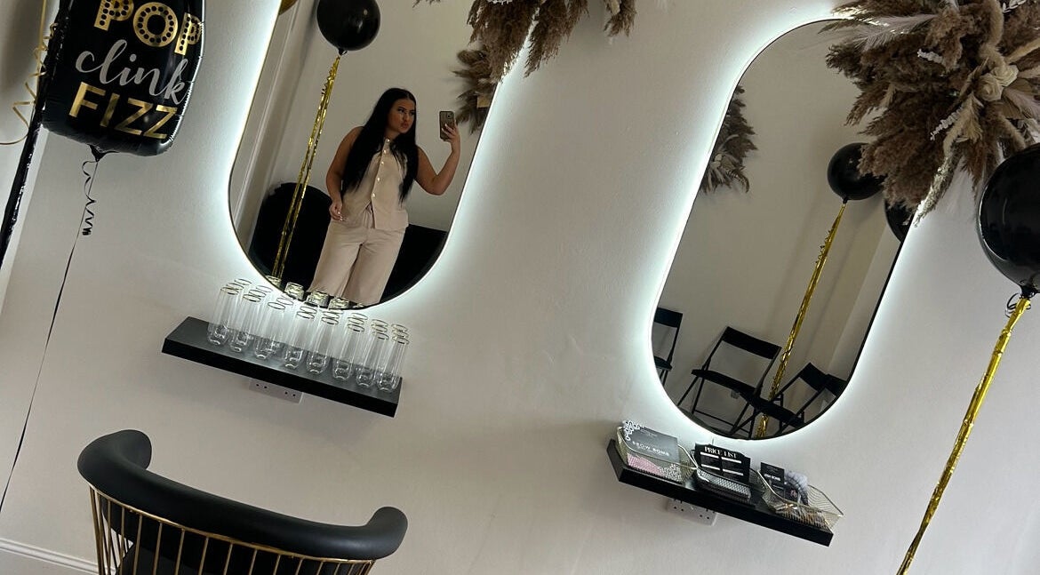 Stylish interior of Dream Beauty in Alexandria, Scotland, featuring modern mirrors and celebratory decor.
