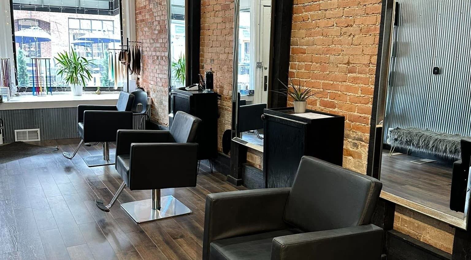 Elegant salon at Stephanie at The Hair Foundation in Northville, Michigan, US with modern styling chairs and mirrors.