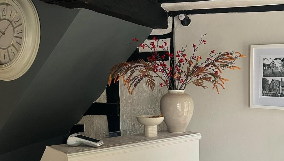 Elegant corner at F I A Nails, Beauty and Wellness, Diss, England, GB with vintage clock and vase décor.