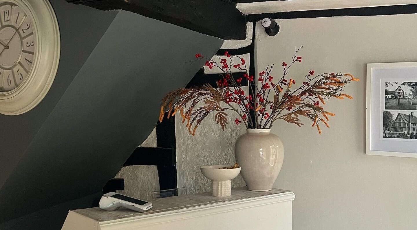 Stylish interior of F I A Nails, Beauty and Wellness in Diss, England, GB with a vase and wall clock.