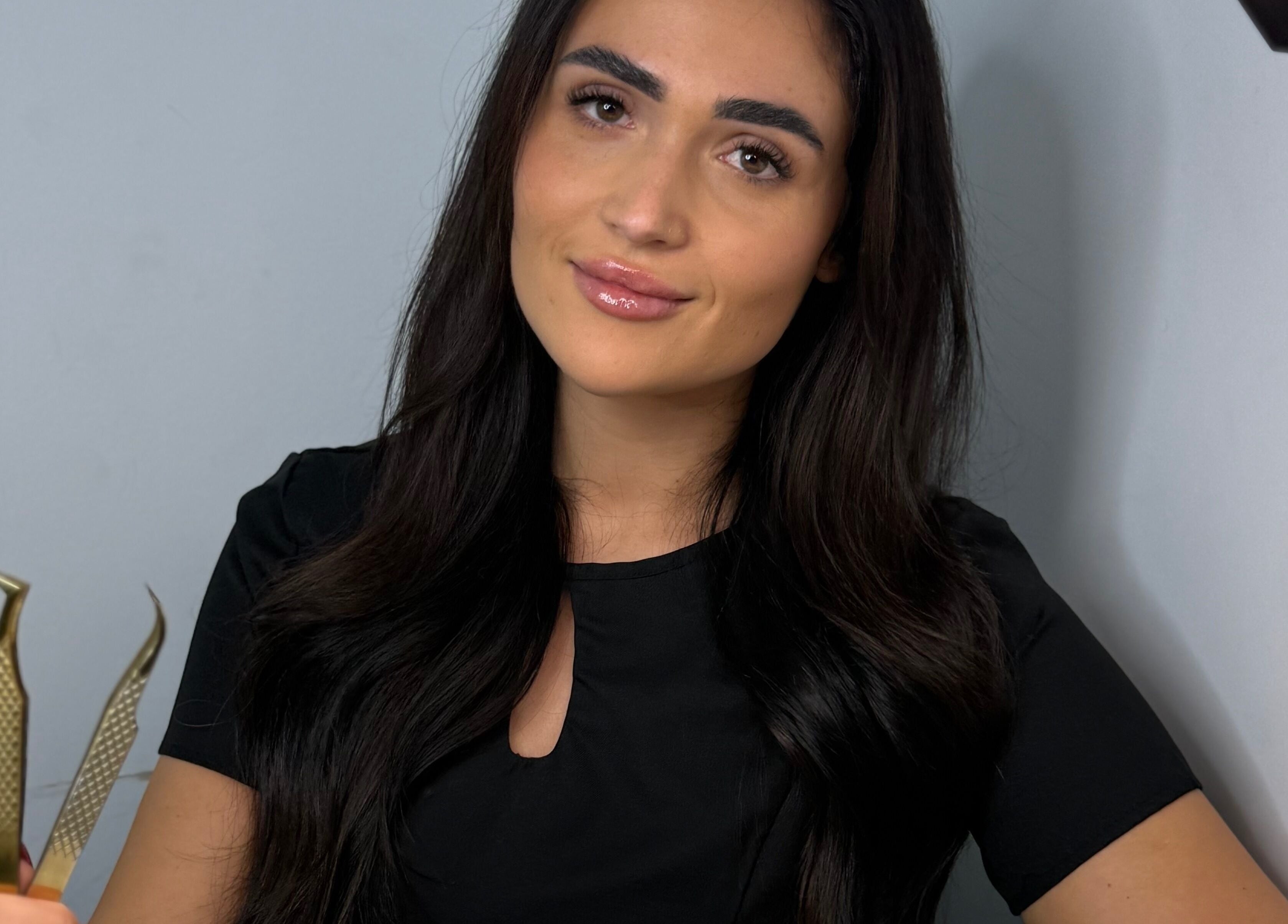 Professional beautician at Mimi’s Studio & Academy, Bournemouth, England, GB holding tweezers.