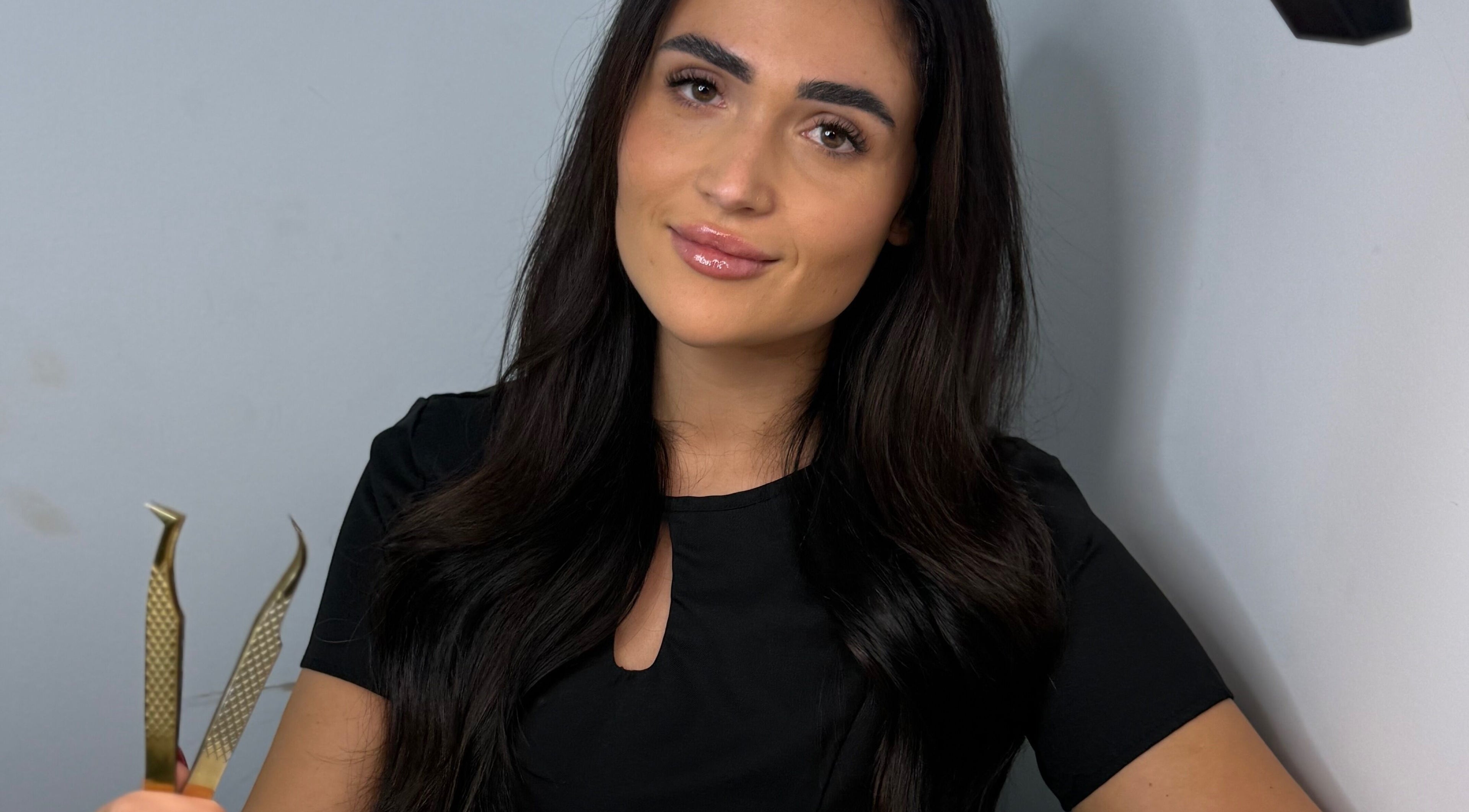 Professional beautician at Mimi’s Studio & Academy, Bournemouth, England, GB holding tweezers.