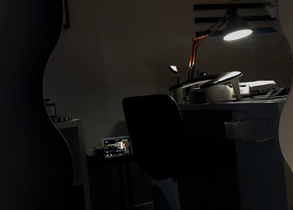 A cozy nail salon desk setup at Gemi Nailz, Cleveland, Queensland, AU, featuring a lamp-lit workspace.