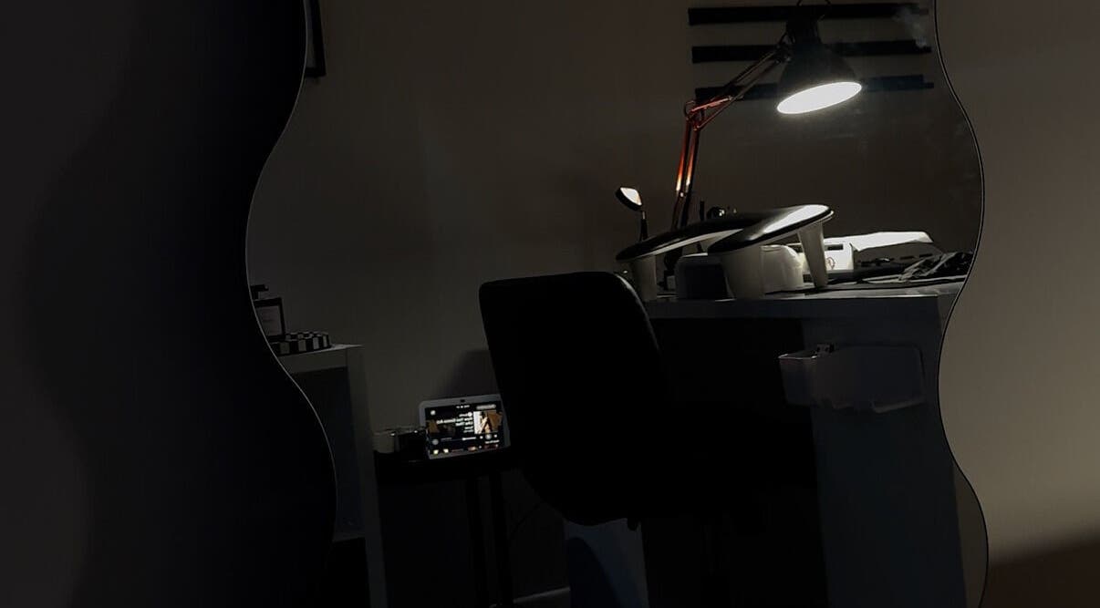 A cozy nail salon desk setup at Gemi Nailz, Cleveland, Queensland, AU, featuring a lamp-lit workspace.