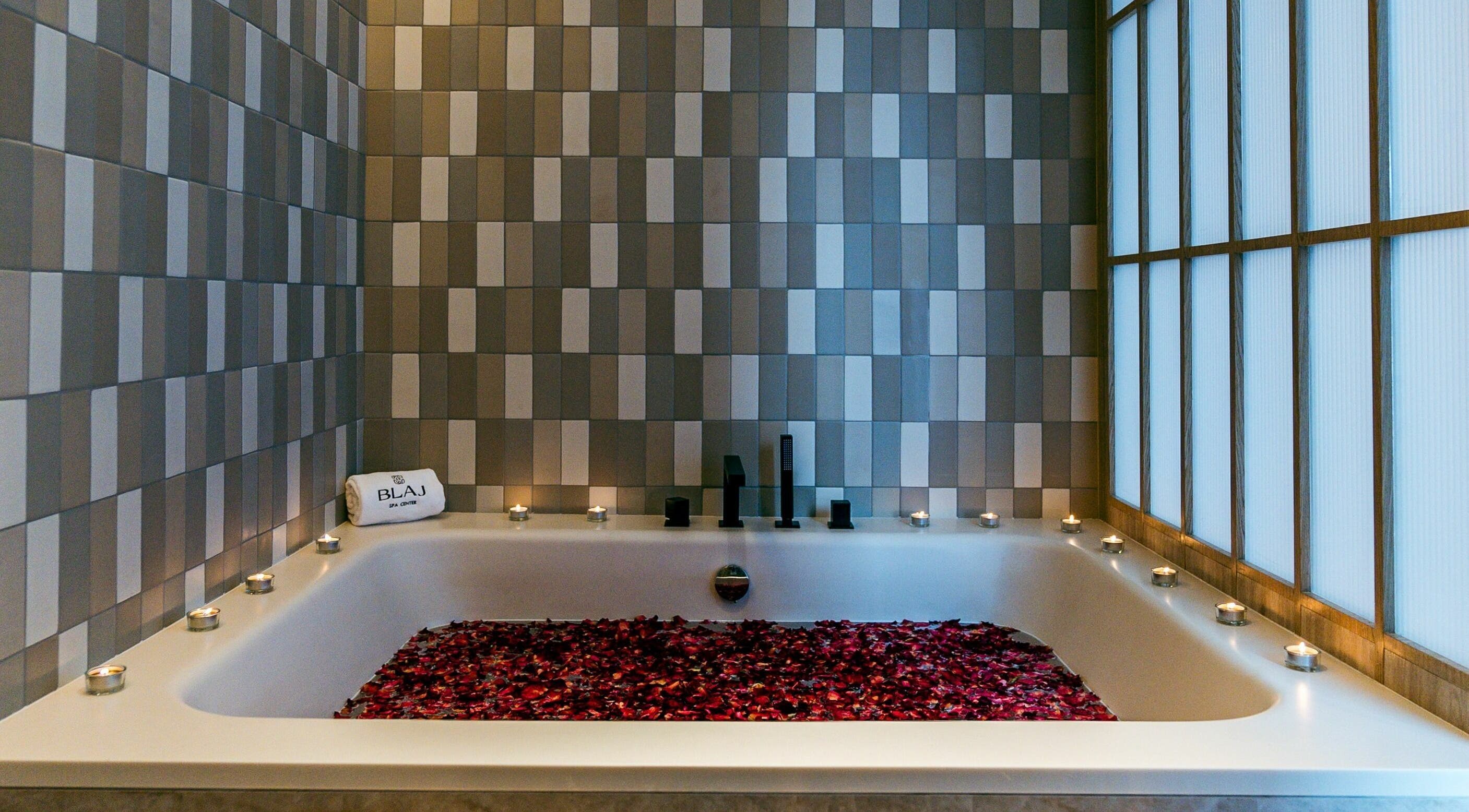 Luxurious rose petal bath at Blaj Spa, Dubai, AE with ambient candles for a serene spa experience.