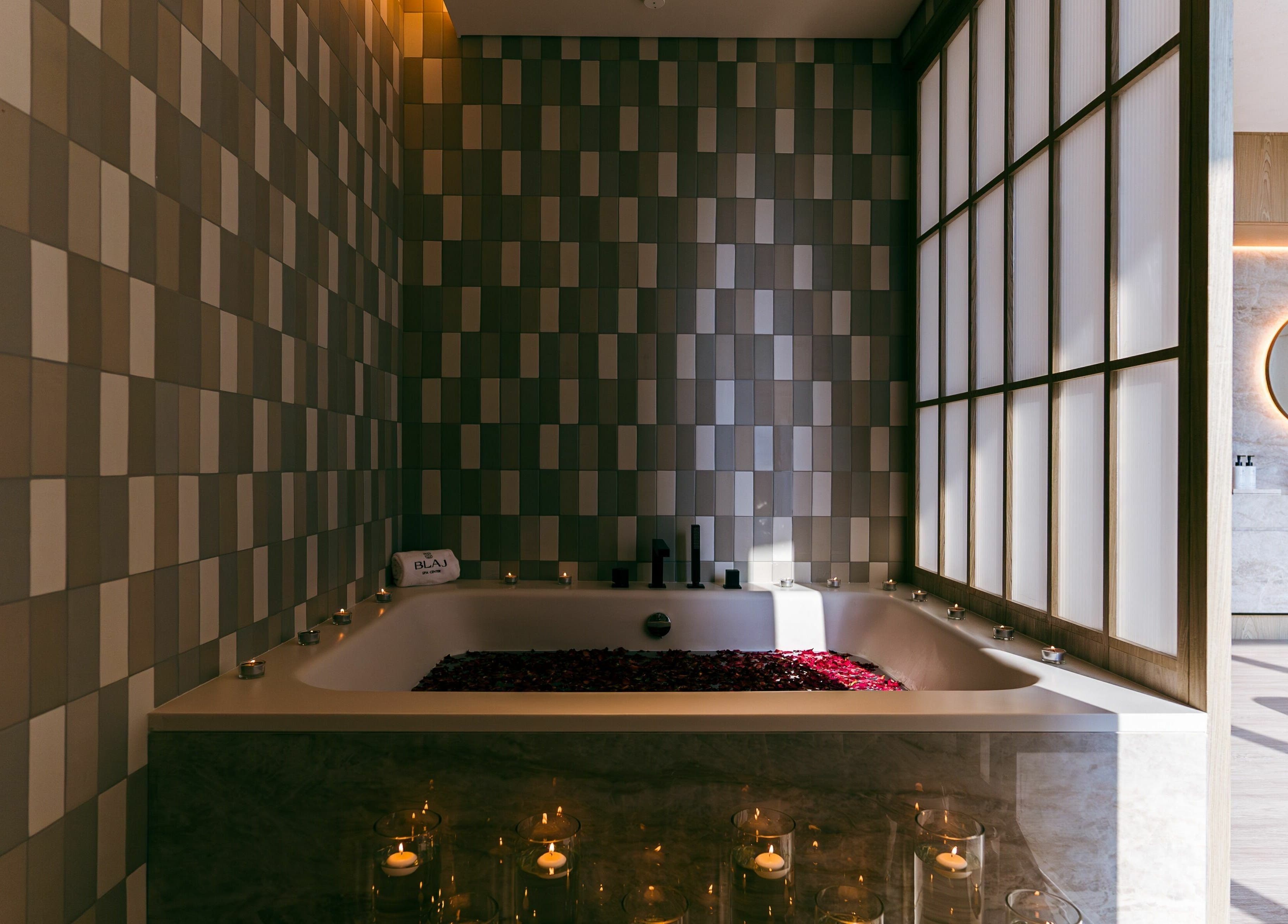 Luxurious bath setup with candles and petals at Blaj Spa, Dubai, AE.