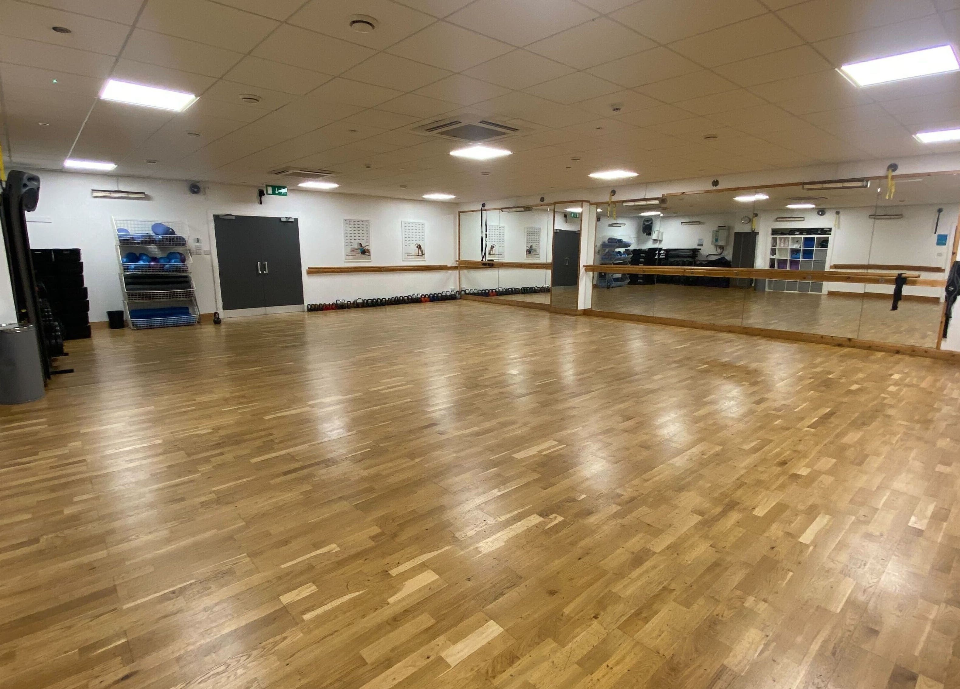 Spacious exercise studio at Mind & Body Studio, Kirkcaldy, Scotland, GB with mirrored walls and wooden floors.