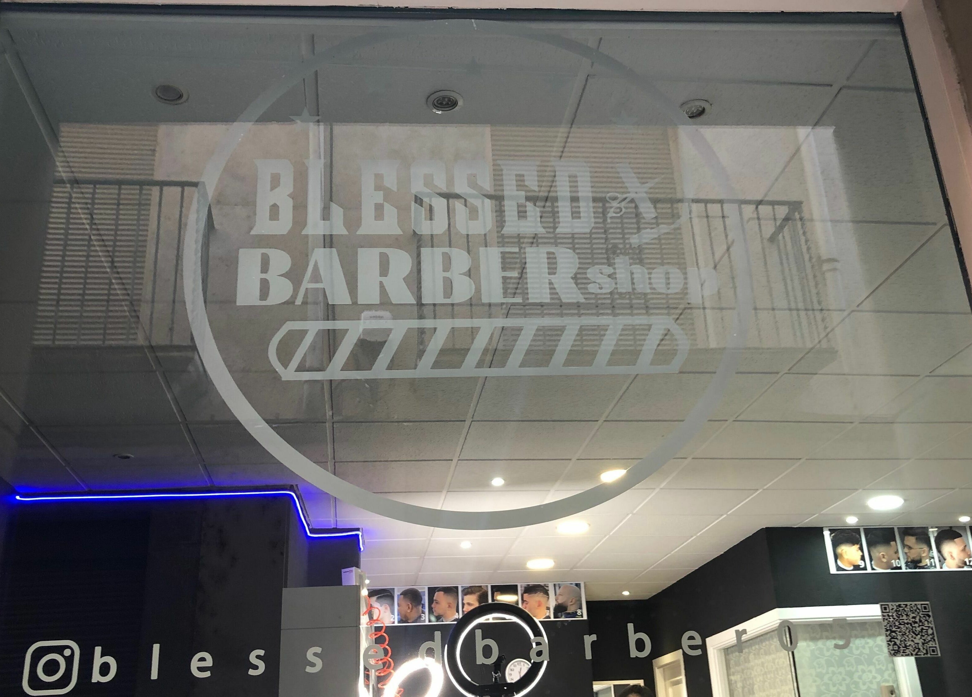 Entrada de Blessed BarberShop en Flix, Catalunya, ES, mostrando logo en vidrio con interior moderno visible.