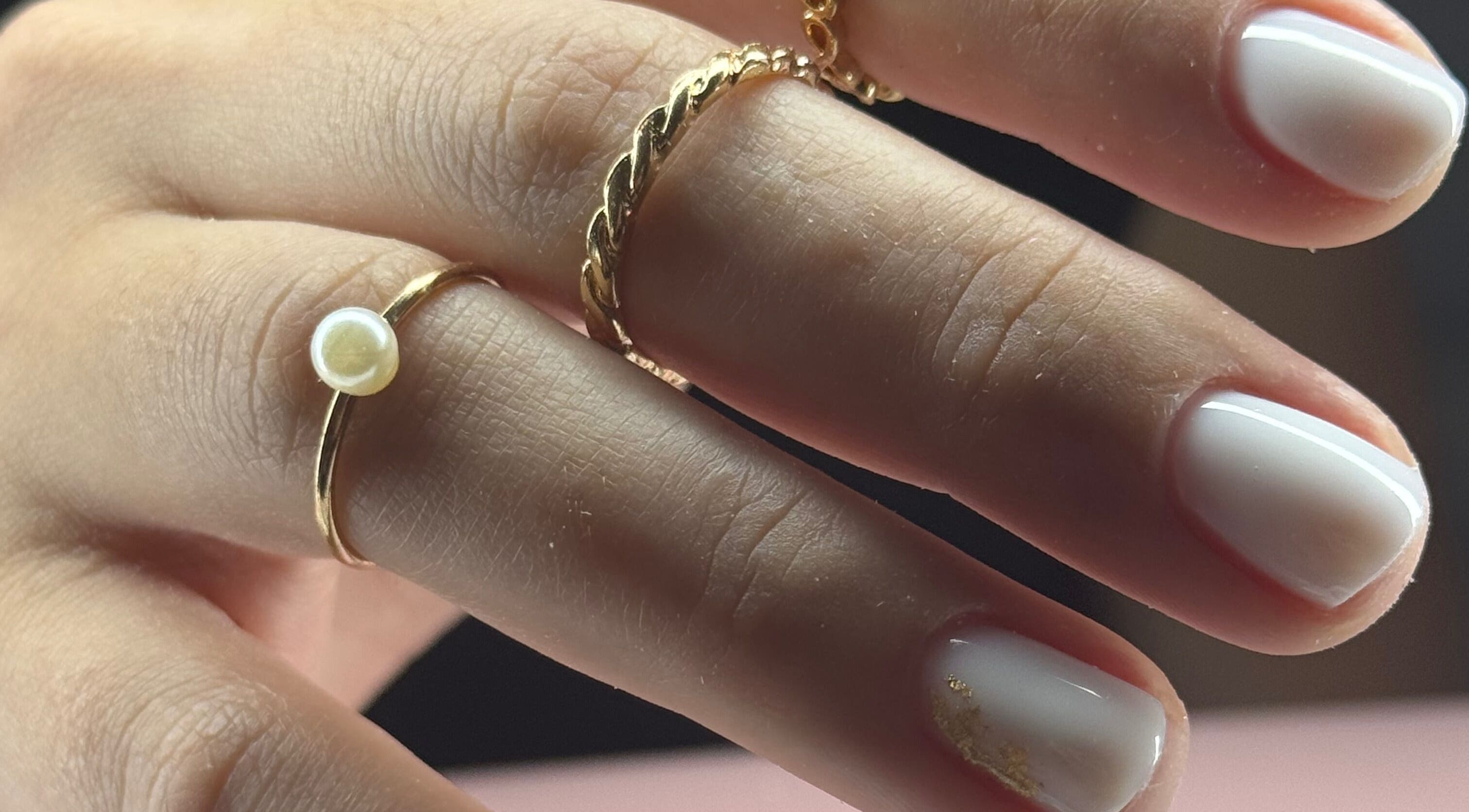 Manicura minimalista de Glambyjoha, Levittown, Toa Baja, PR, con anillos de oro y uñas blancas.