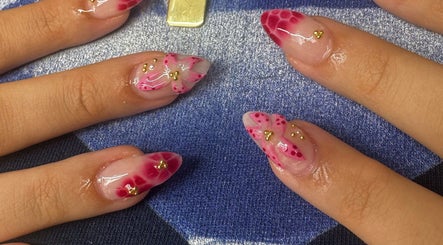 Intricate floral nail art at Byhollie, Rochdale, England, GB showcasing pink designs with gold accents.